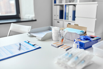 medicine, vaccination and healthcare concept - syringes, vaccine, protective medical gloves and plasters on table at hospital