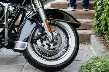 Ruota di motocicletta cromata custom, con dettaglio di pneumatici e freni a disco di lusso....