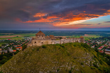 Sumeg, Hungary - Aerial panoramic view of the famous High Castle of Sumeg in Veszprem county at sunset with storm clouds and dramatic colors of sunset at background on a summer afternoon