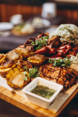 assorted various meat and vegetable dishes laid out on the village board for serving in a restaurant of Ukrainian cuisine