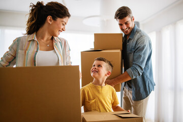 Family unpacking cardboard boxes at new home