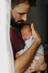 home photos of a newborn baby in the arms of father. Selective focus, noise effect - obrazy, fototapety, plakaty