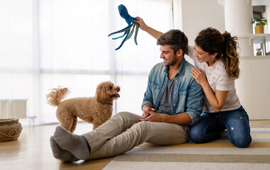 Happy family playing with their dog at home. People animal pet love concept