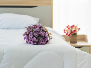 attractive luxury white bed elegantly decorated by beautiful bunch of purple and pink flower as special romantic sweet gift for love celebration or wedding event or engagement