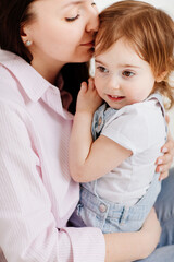 beautiful happy family sit on floor and cuddle in white photo studio.