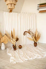 White canvas in a photo studio and an element of decor. Dried flowers