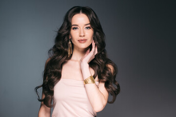Naklejka premium Beautiful woman with long hair, shine and curly, beauty girl female over darl gray background