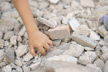 Kid hands finding something in concrete debris