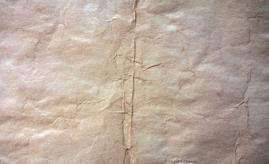 Photo of the texture of old yellowed paper with crumpled stripes and spots.