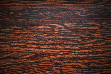 Photo of mahogany veneer texture with dark stripes. Wooden background