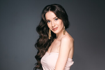 Fototapeta premium Beautiful woman with long hair, shine and curly, beauty girl female over darl gray background