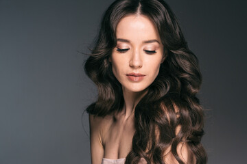 Fototapeta premium Beautiful woman with long hair, shine and curly, beauty girl female over darl gray background