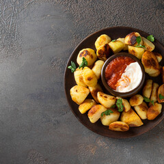Popular Spanish tapa. Patatas bravas, fried potatoes served with spicy tomato sauce and aioli on concrete table.Top view,copy space