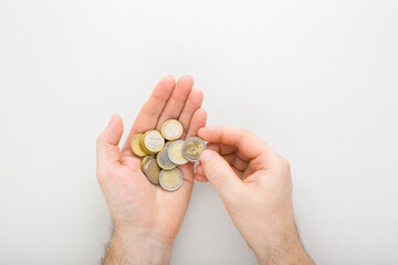 Young adult man hands counting euro coins on light gray table background. Point of view shot....