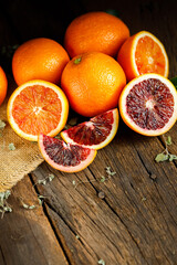 Sliced Sicilian Blood oranges fruits over old dark wooden background. Top view.
