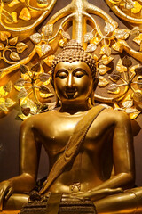 Golden Buddha statue with golden bodhi tree