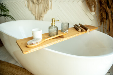 Stylish bathroom interior in boho style. The bathroom has a shelf for brushes, soap and body oils. © Arina