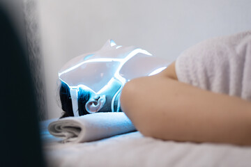 Woman with led light therapy facial and neck beauty mask photon therapy. Home skincare and me time...