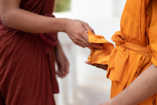 The monk is wearing the robe to the newly ordained monks in the temple, during the Buddhist ordination ceremony.