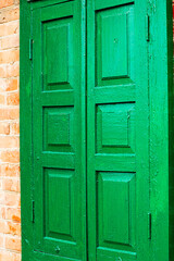 old vintage wooden green painted shutters covering the window