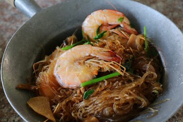 Casseroled shrimp with glass noodle in pot. Seafood concept.
