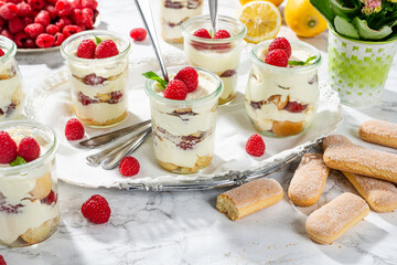 raspberries tiramisu in glass on marble background