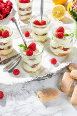 raspberries tiramisu in glass on marble background