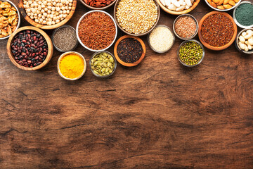 Superfoods, legumes, cereals, nuts, seeds set in bowls on wooden background. Superfood as chia,...