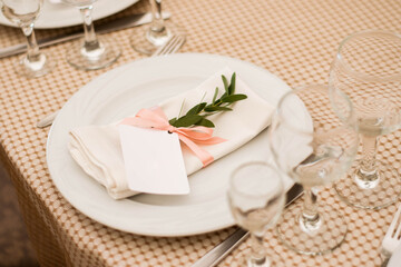 Card with eucalyptus branch on a banquet table. Wedding day.