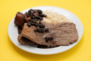 fried meat with beans and boiled rice on the plate