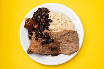 fried meat with beans and boiled rice on the plate