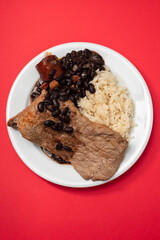fried meat with beans and boiled rice on the plate