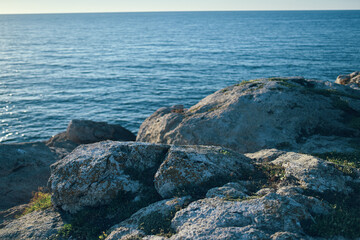 Fototapeta na wymiar Rock beach summer clear water sea ocean landscape stones