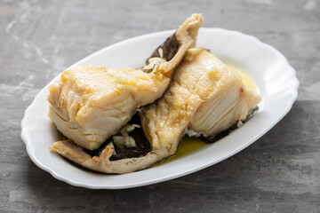 boiled cod fish with olive oil on white dish