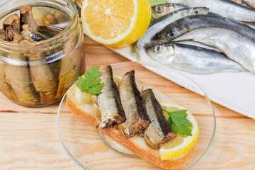 Open sandwich with preserved smoked sprats and ingredients, close-up