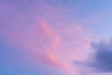 Picture of blue sky, purple pink, and white and gray clouds.