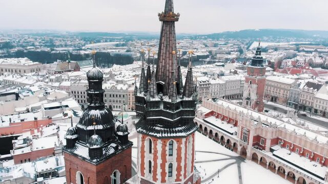 Slow-motio footage of Old city center. Closeup of Adam Mickiewicz monument, St. Mary's Basilica in the city of Krakow, Poland. City skyline. Old buildings with a background of clear white sky. 