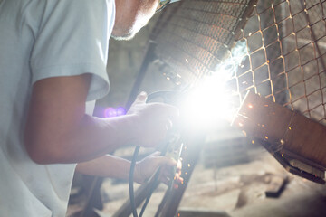 Men are welding iron to make a dog cage.close up