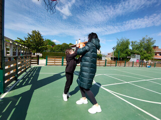 Playing ball with a mask on with her kid on the swings