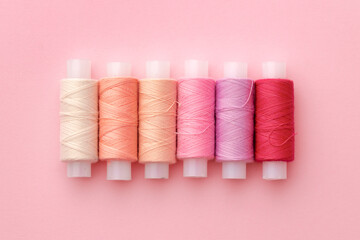 Set of threads spools on pink background