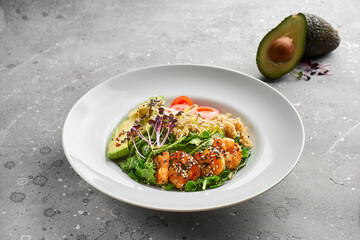 Close-up, Bowl with tiger prawns, quinoa and avocado and olive oil on gray stone background.