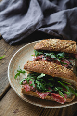 Sandwich with whole grain bread, salami and arugula