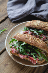 Sandwich with whole grain bread, salami and arugula
