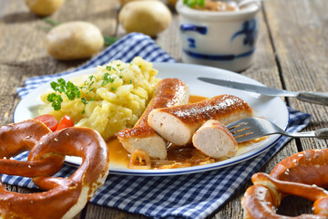 Der Wollwurst-Klassiker – Gebratene bayerische Geschwollene mit Kartoffelsalat, Bratensauce und frischen Brezen  - Roasted Bavarian sausages with homemade potato salad, gravy and fresh pretzels