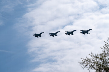 fighter jets in the blue sky and clouds. rehearsal of the victory parade. military action, bombing. Airshow.