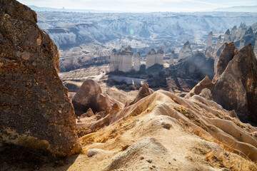View from top place on the strange landscape in the Cappadocia valley with yellow mountains, rocks and hills and blue sky with white clouds