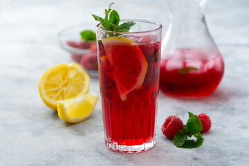 Summer raspberries cold drink with lemon, mint and berries. Homemade cocktail.