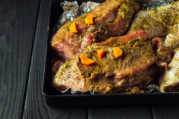 Raw meat mutton and chicken legs on a baking sheet are prepared for baking in the oven. The national meat dish is prepared on the eve of the holidays