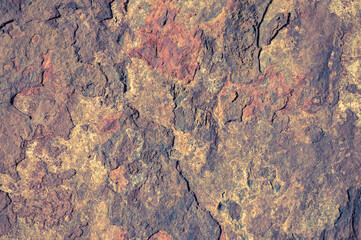 Rough texture of the stone with iron oxides and flaking fragments. Background