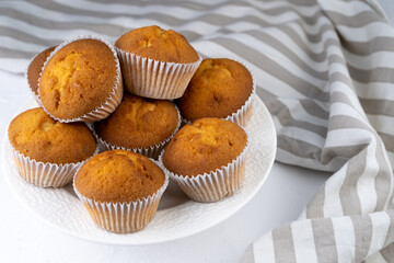 Biscuit muffins close-up. Sweet pastries. Party treat. Dessert on white table - homemade muffins. Portioned cupcakes. Simple muffin